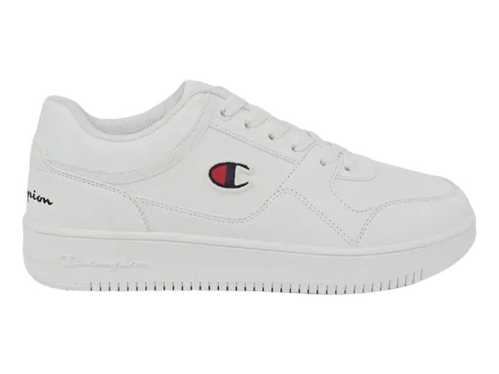 Tenis deportivos Champion de color blanco con logotipo lateral en rojo y azul, diseño casual y suela plana.