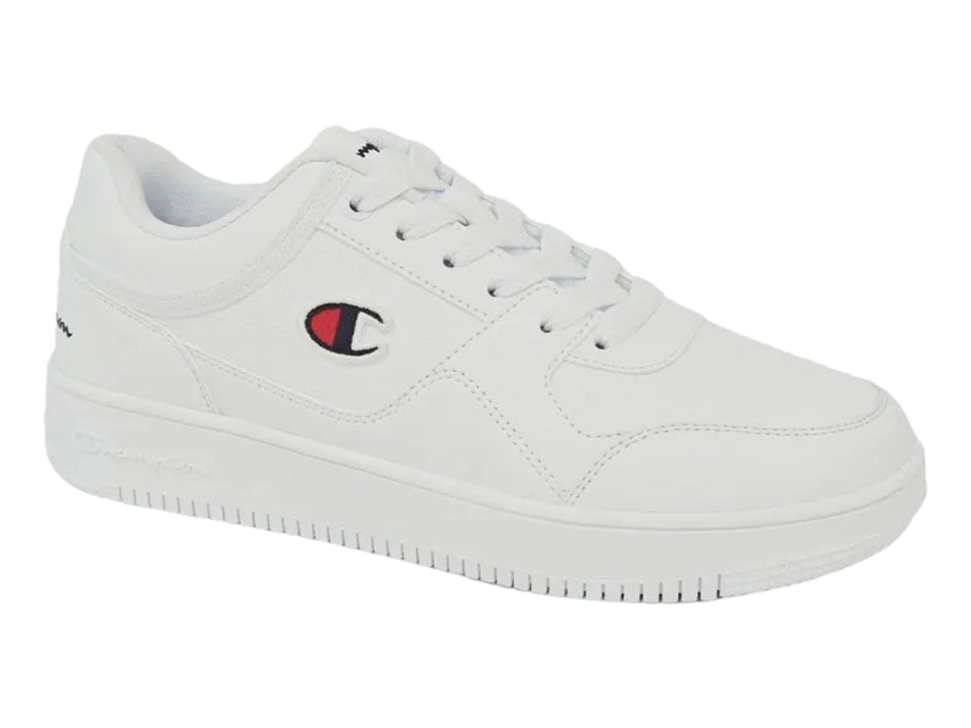Tenis deportivos Champion de color blanco con logotipo lateral en rojo y azul, diseño casual y suela plana.