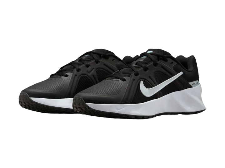 Tenis Nike deportivos en color negro con suela blanca gruesa, vista lateral.