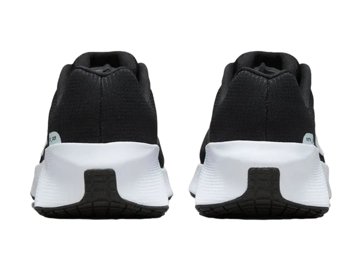 Tenis Nike deportivos en color negro con suela blanca gruesa, vista lateral.