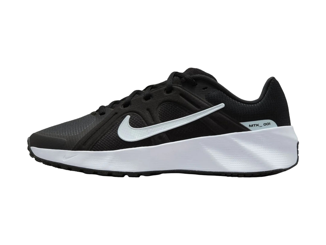 Tenis Nike deportivos en color negro con suela blanca gruesa, vista lateral.