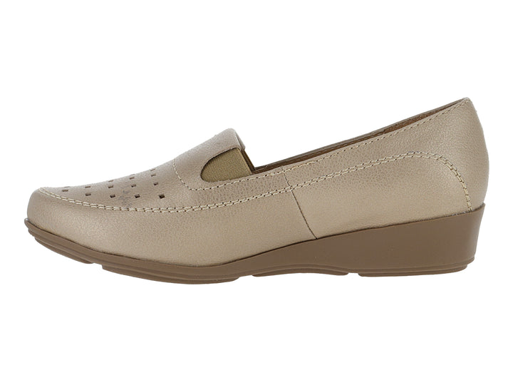 Zapato mocasín color beige metálico con suela de cuña y detalles perforados en la parte frontal.