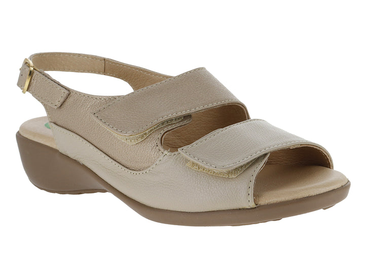 Sandalia beige de marca Capricho con cierre de velcro, hebilla en el tobillo y suela de cuña color café.