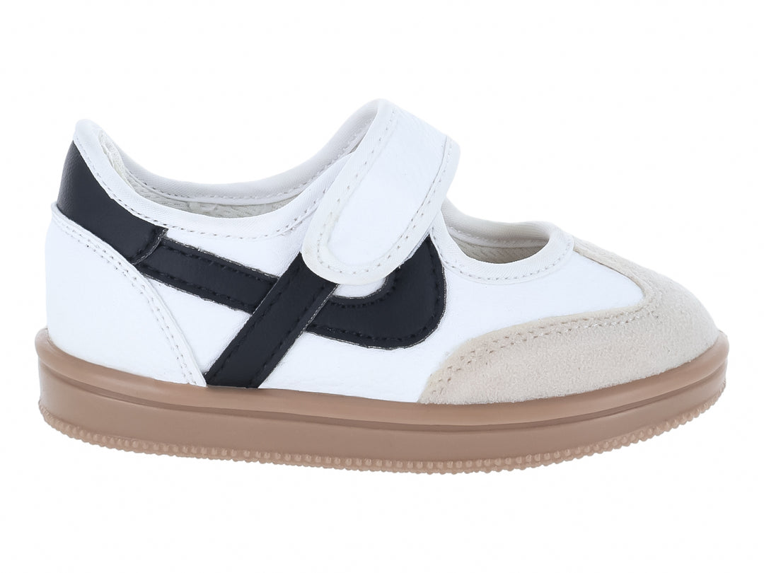 Tenis blancos para niño con detalles en negro, cierre de velcro y suela color beige.