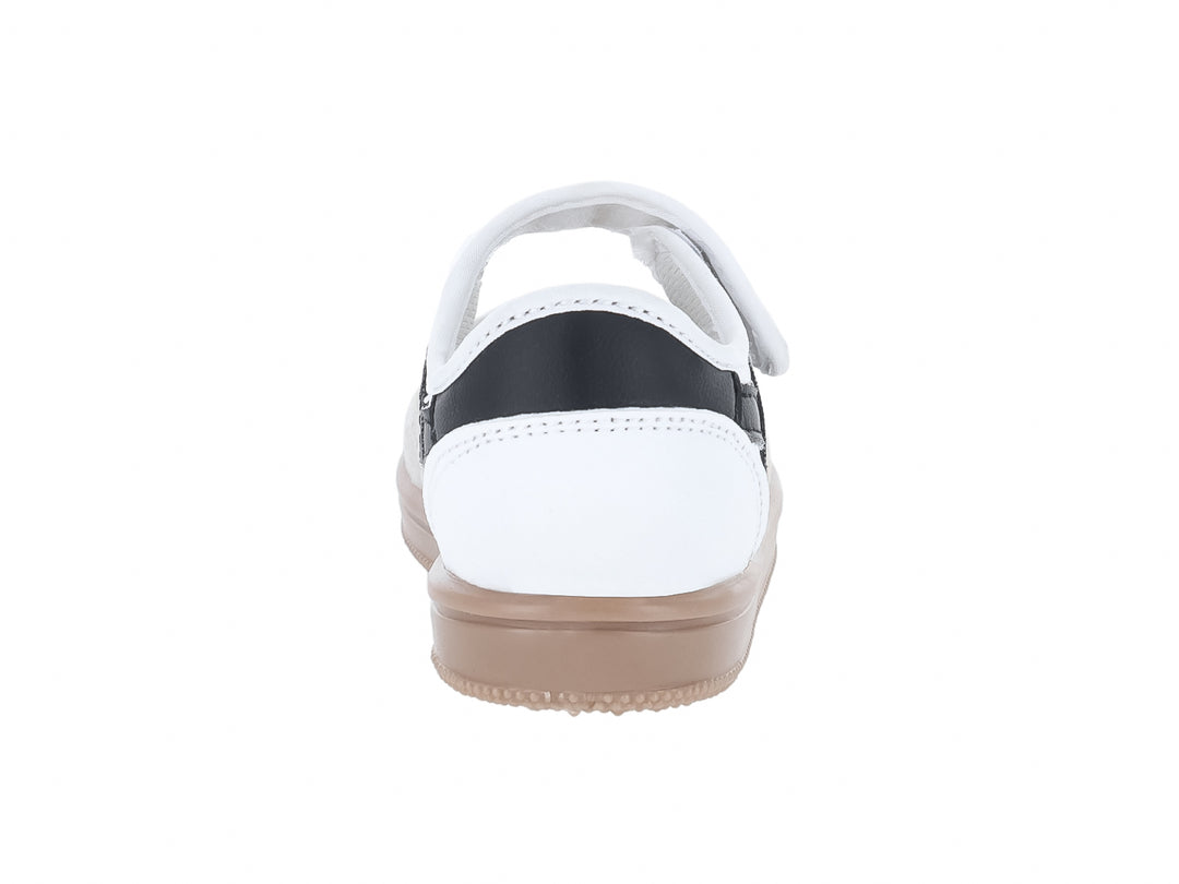 Tenis blancos para niño con detalles en negro, cierre de velcro y suela color beige.