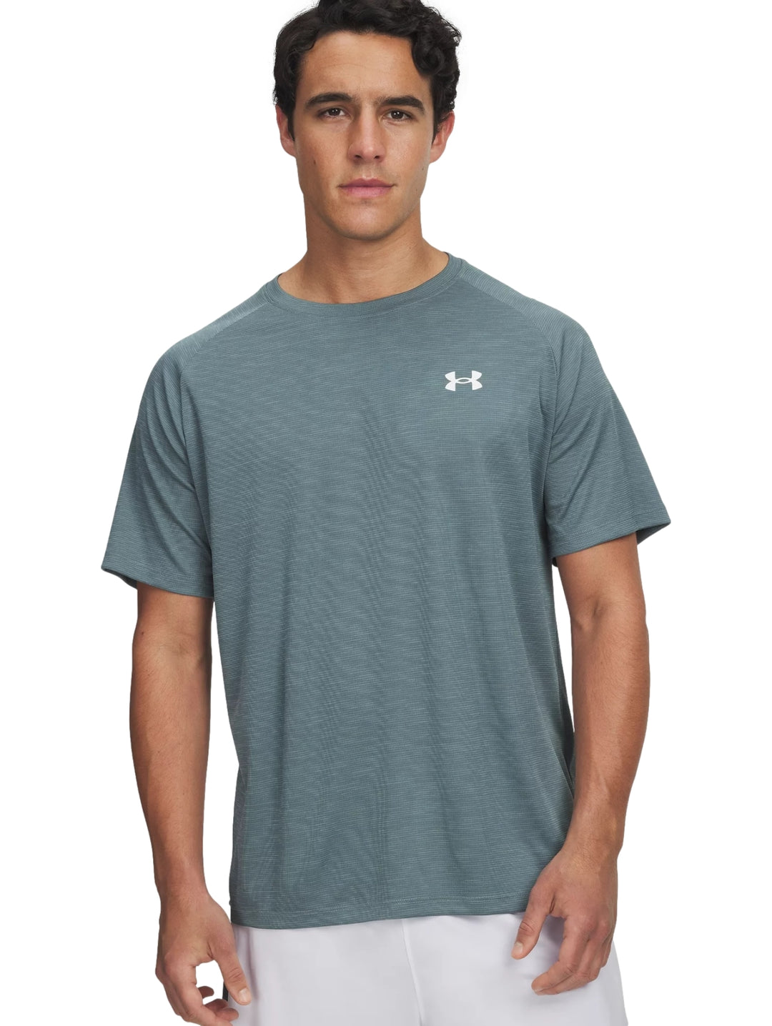 Hombre vistiendo playera deportiva de manga corta color azul con logo de Under Armour en el pecho.
