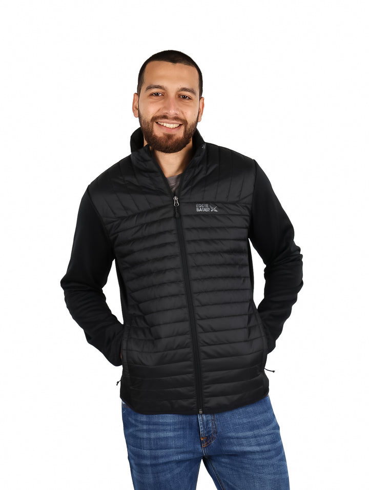 Hombre vistiendo una chamarra acolchada color negro de la marca Eddie Bauer.