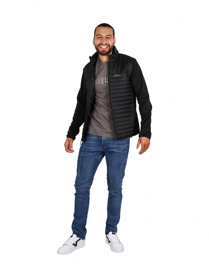 Hombre vistiendo una chamarra acolchada color negro de la marca Eddie Bauer.