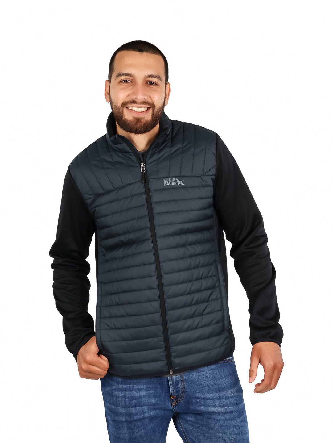 Hombre vistiendo chamarra híbrida Eddie Bauer color storm con chaleco acolchado y mangas negras.