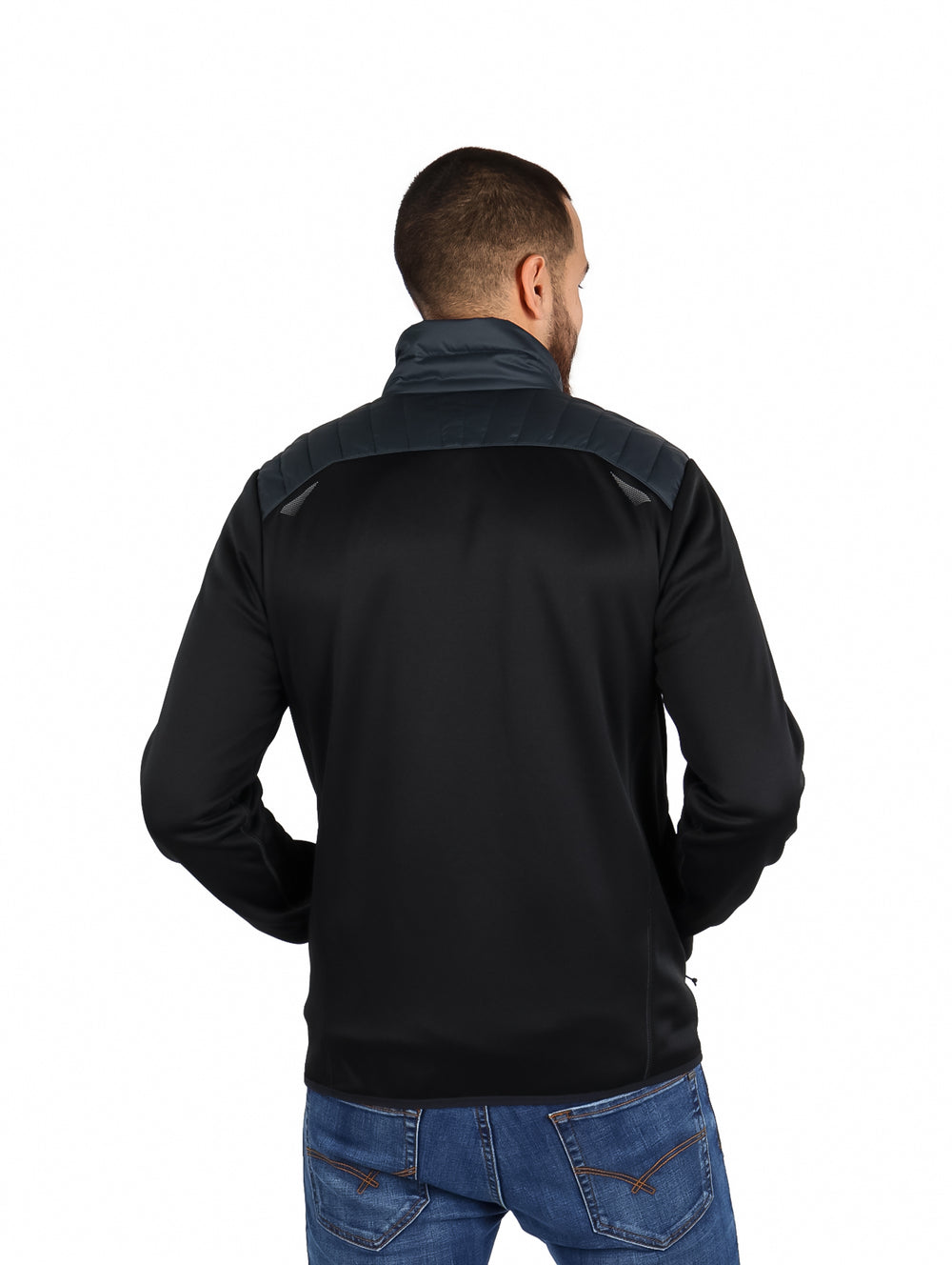 Hombre vistiendo chamarra híbrida Eddie Bauer color storm con chaleco acolchado y mangas negras.