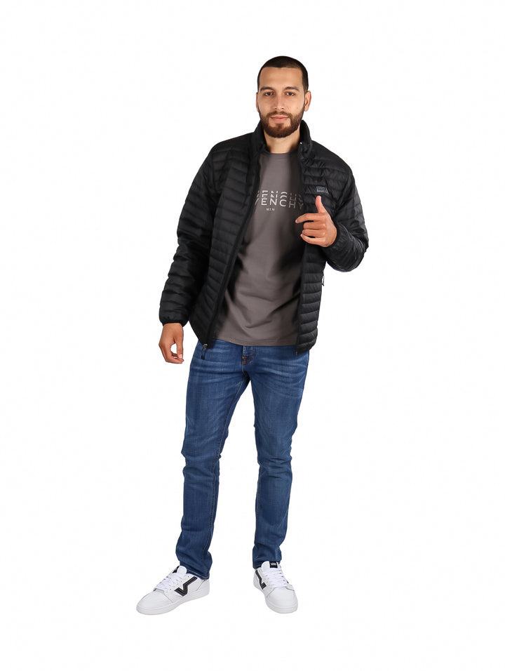 Hombre vistiendo una chamarra acolchada color negro de la marca Eddie Bauer.