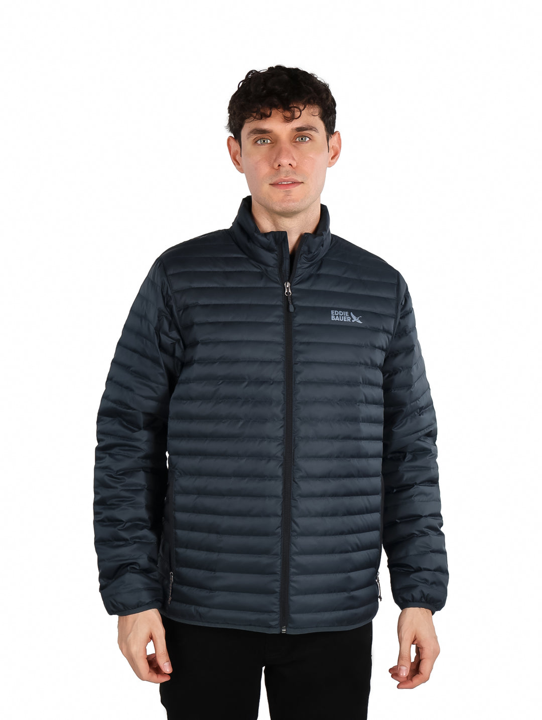 Hombre vistiendo chamarra acolchada color gris oscuro de la marca Eddie Bauer.