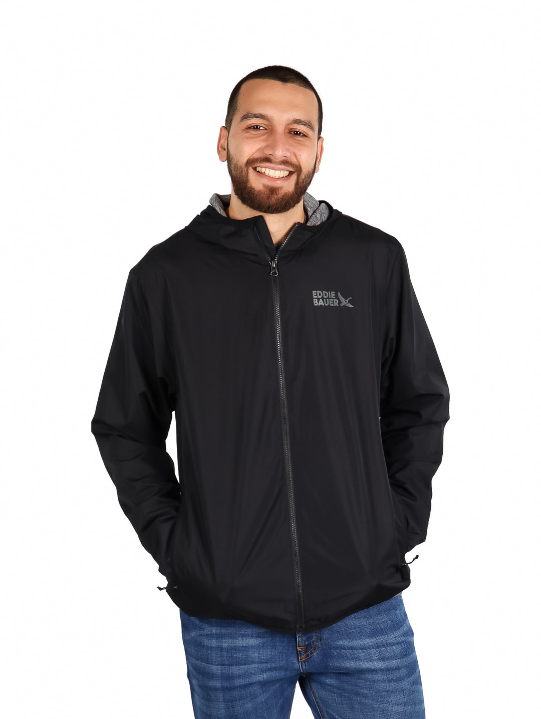 Hombre vistiendo una chaqueta rompevientos color negro de la marca Eddie Bauer con capucha.