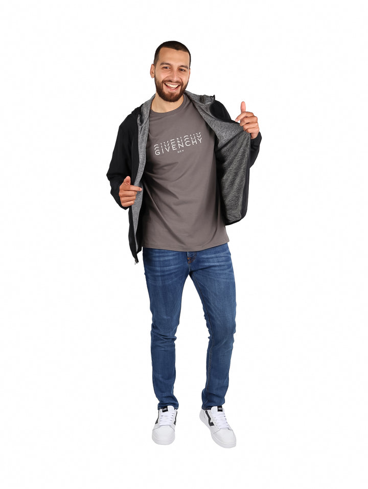Hombre vistiendo una chaqueta rompevientos color negro de la marca Eddie Bauer con capucha.
