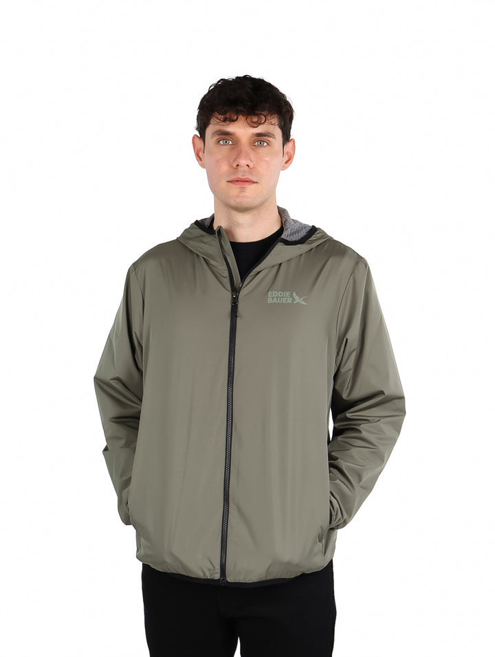 Hombre vistiendo una chamarra verde con capucha de la marca Eddie Bauer.