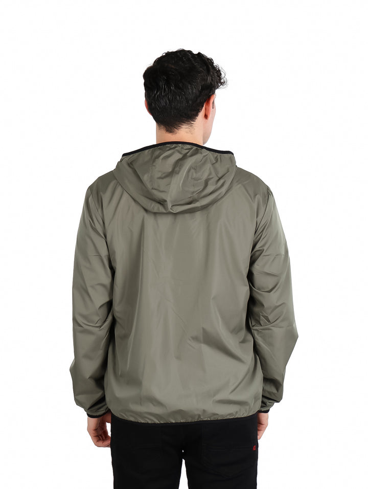 Hombre vistiendo una chamarra verde con capucha de la marca Eddie Bauer.