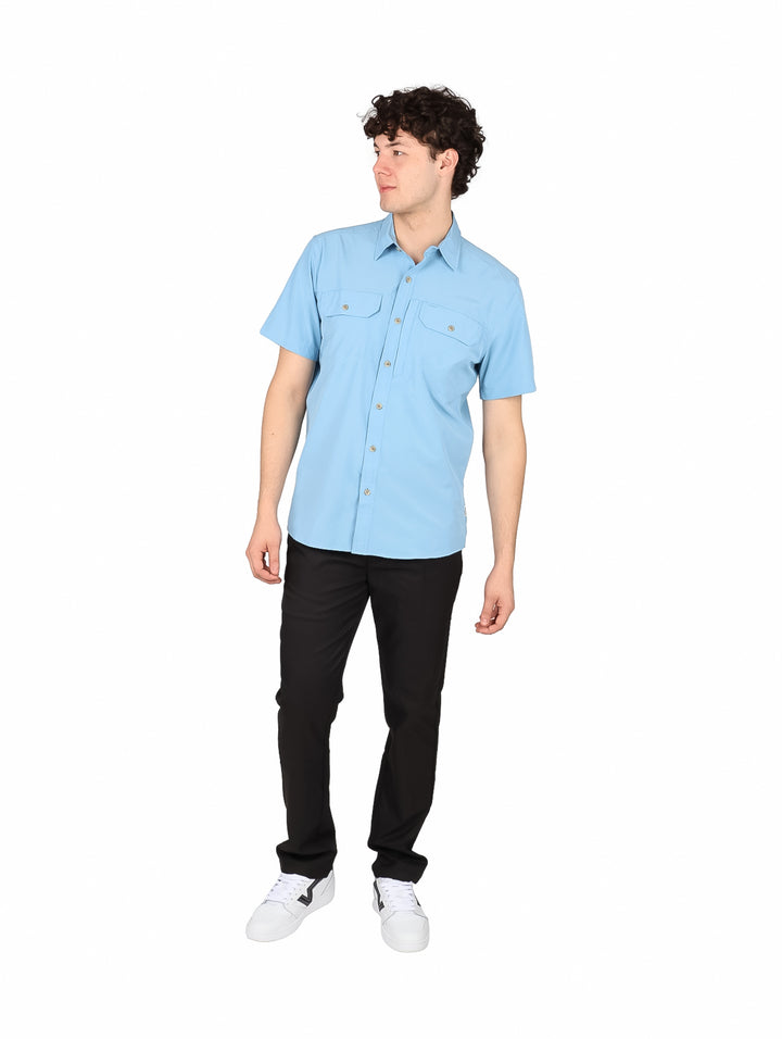 Hombre vistiendo una camisa de manga corta color azul claro con dos bolsillos frontales.