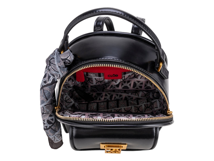Mochila negra Cloe con herraje dorado y un pañuelo decorativo gris atado al asa superior.