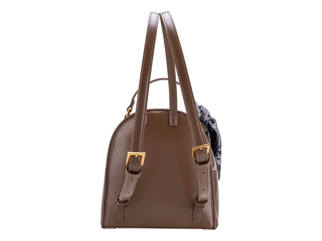 Bolso tipo mochila color café de la marca Cloe con detalle de pañuelo gris y herrajes dorados.