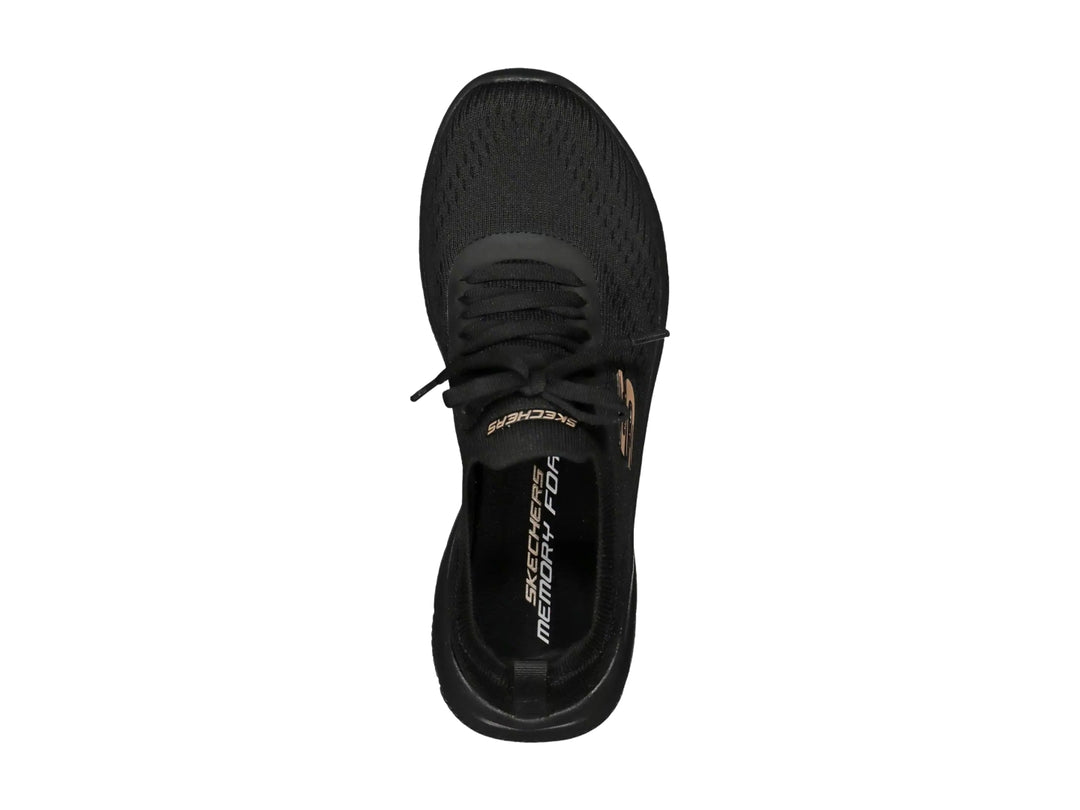 Tenis deportivos Skechers para mujer en color negro con detalles dorados y suela flexible.