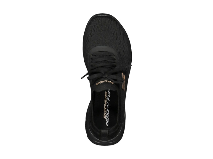 Tenis deportivos Skechers para mujer en color negro con detalles dorados y suela flexible.