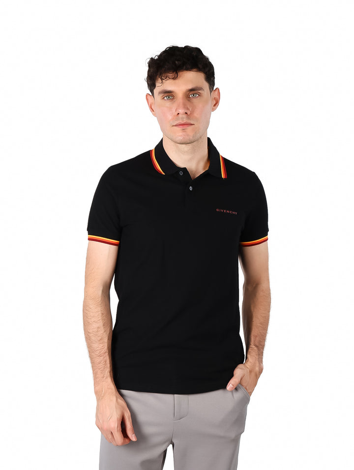Hombre vistiendo polo negro de Givenchy con detalles de rayas coloridas en el cuello y los bordes de las mangas.