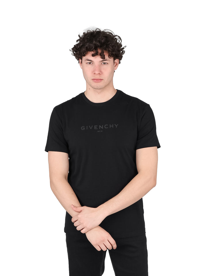 Hombre vistiendo una camiseta casual de manga corta color negro con logotipo de Givenchy en el pecho.
