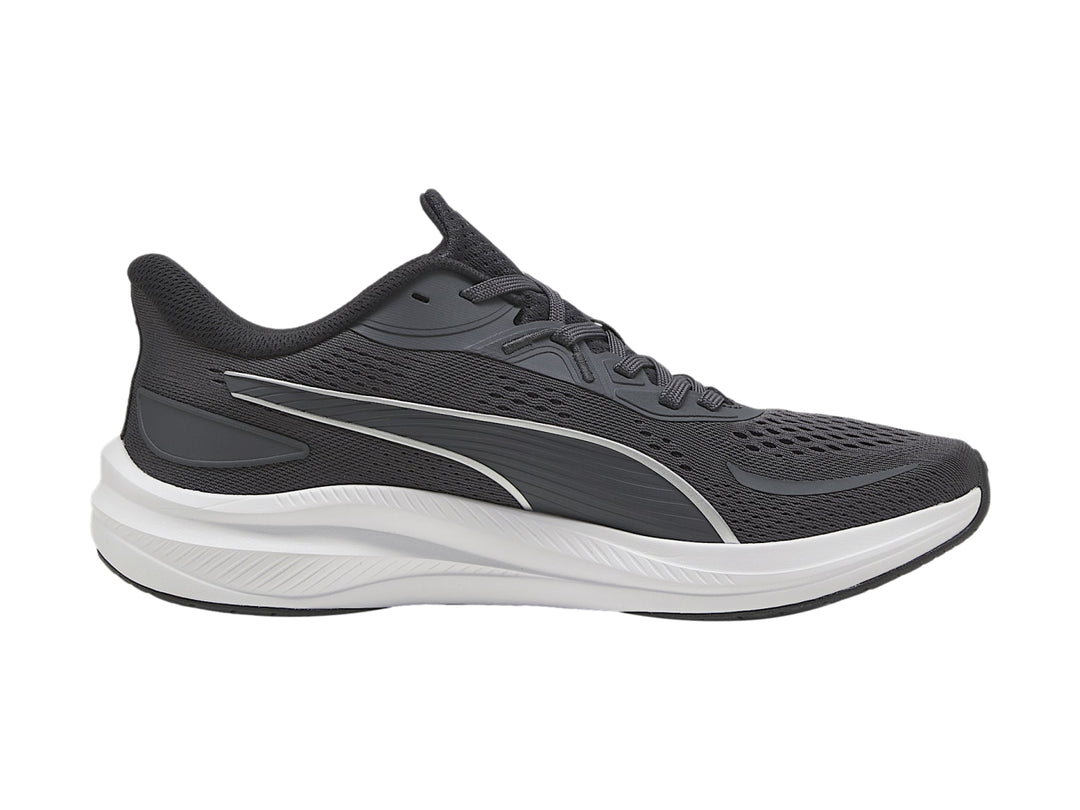 Tenis deportivos PUMA en color gris oscuro con suela blanca y franja plateada lateral.