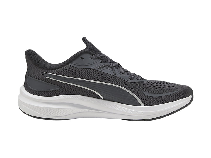 Tenis deportivos PUMA en color gris oscuro con suela blanca y franja plateada lateral.