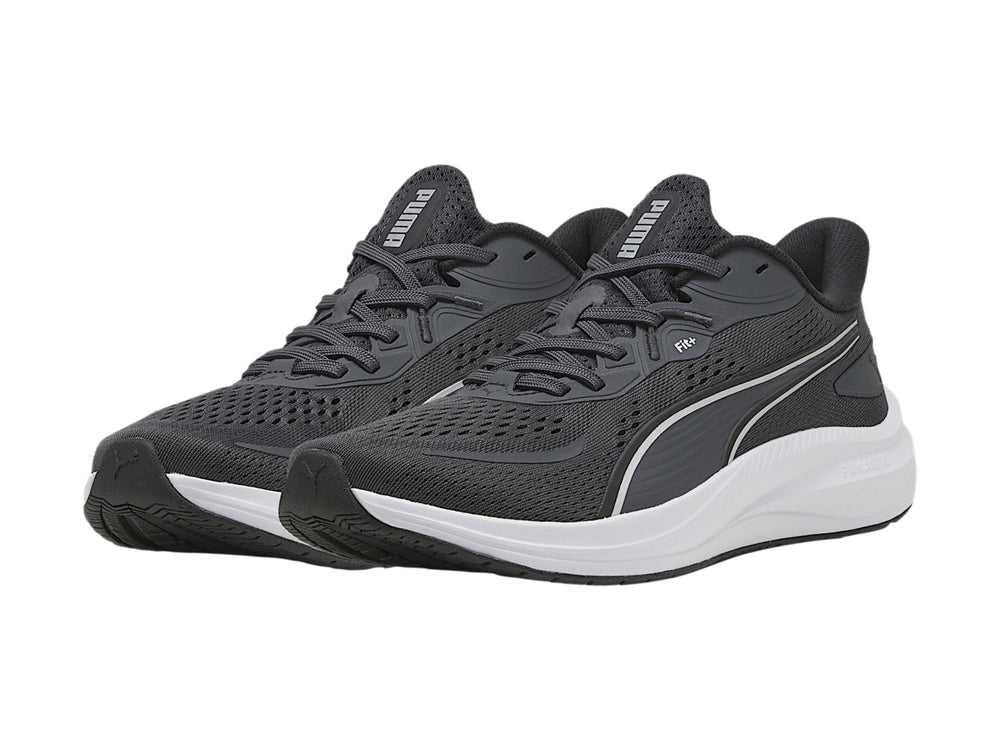 Tenis deportivos PUMA en color gris oscuro con suela blanca y franja plateada lateral.