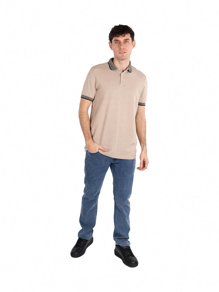 Hombre vistiendo playera polo color khaki con detalles en gris oscuro en el cuello y mangas.