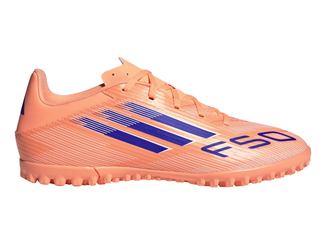 Calzado de fútbol Adidas F50 color naranja con rayas azules y suela para césped sintético.