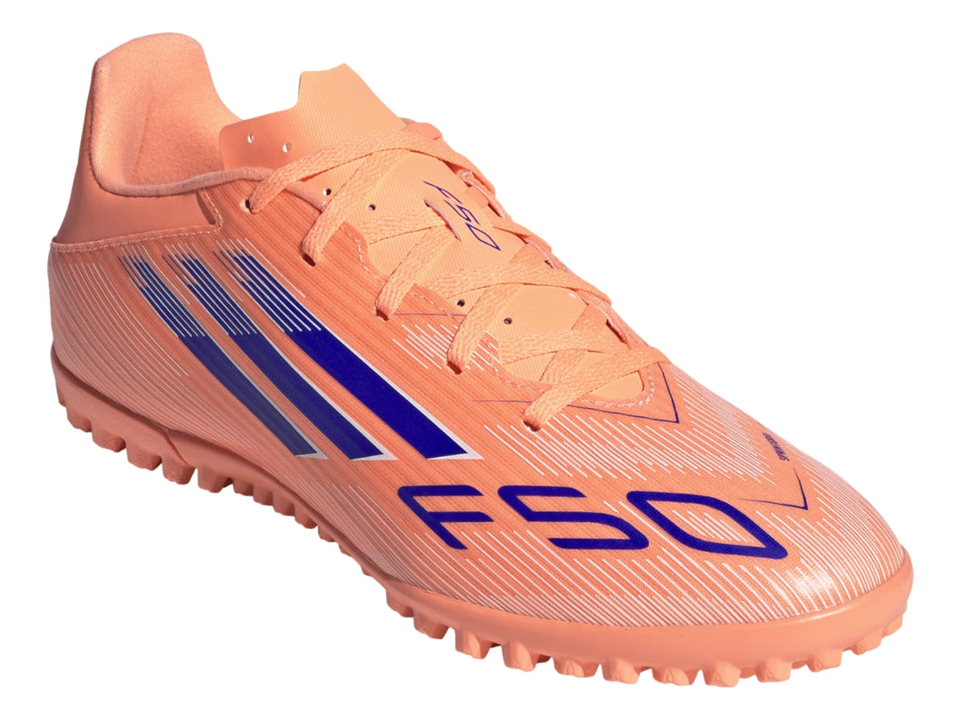 Calzado de fútbol Adidas F50 color naranja con rayas azules y suela para césped sintético.