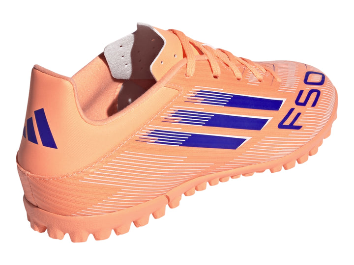 Calzado de fútbol Adidas F50 color naranja con rayas azules y suela para césped sintético.