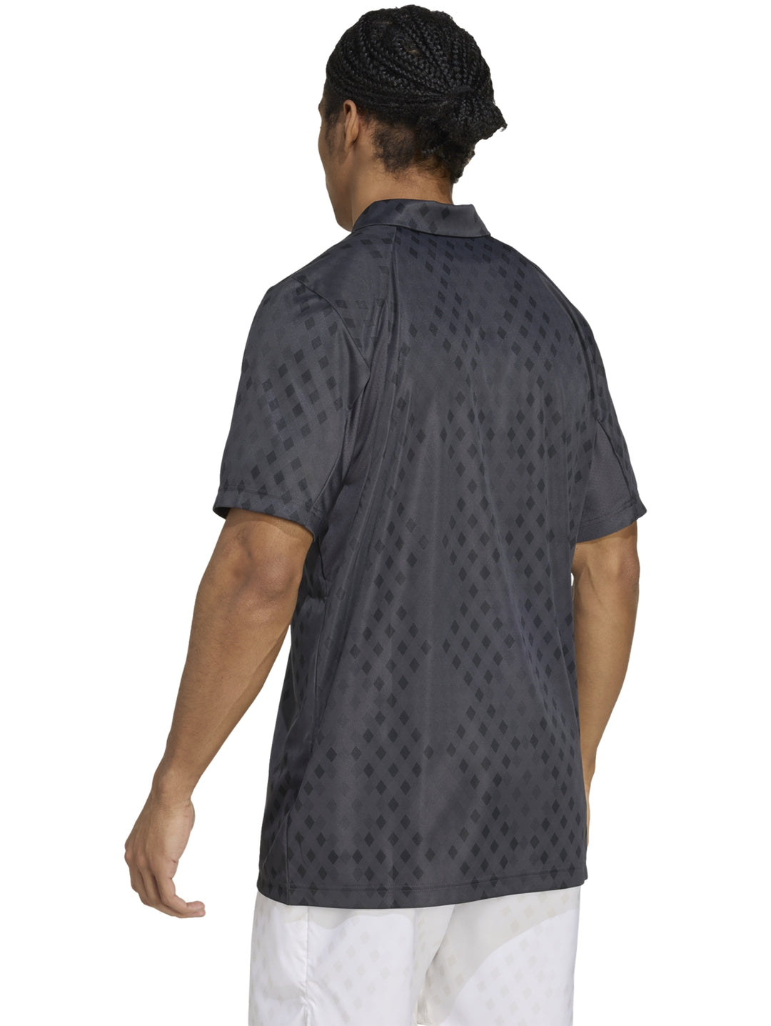 Hombre vistiendo polo deportivo Adidas color gris oscuro con patrón geométrico de diamantes.