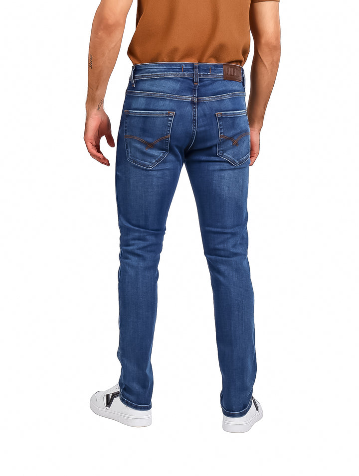 Hombre vistiendo pantalones jeans de color azul índigo con corte recto y calzado blanco.