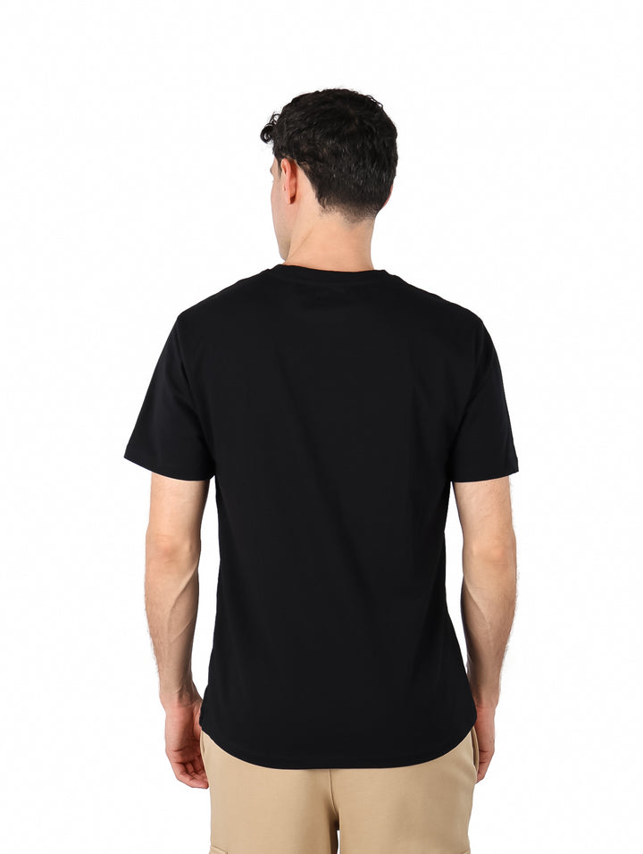 Hombre vistiendo una camiseta negra de manga corta con logotipo DKNY en el pecho.