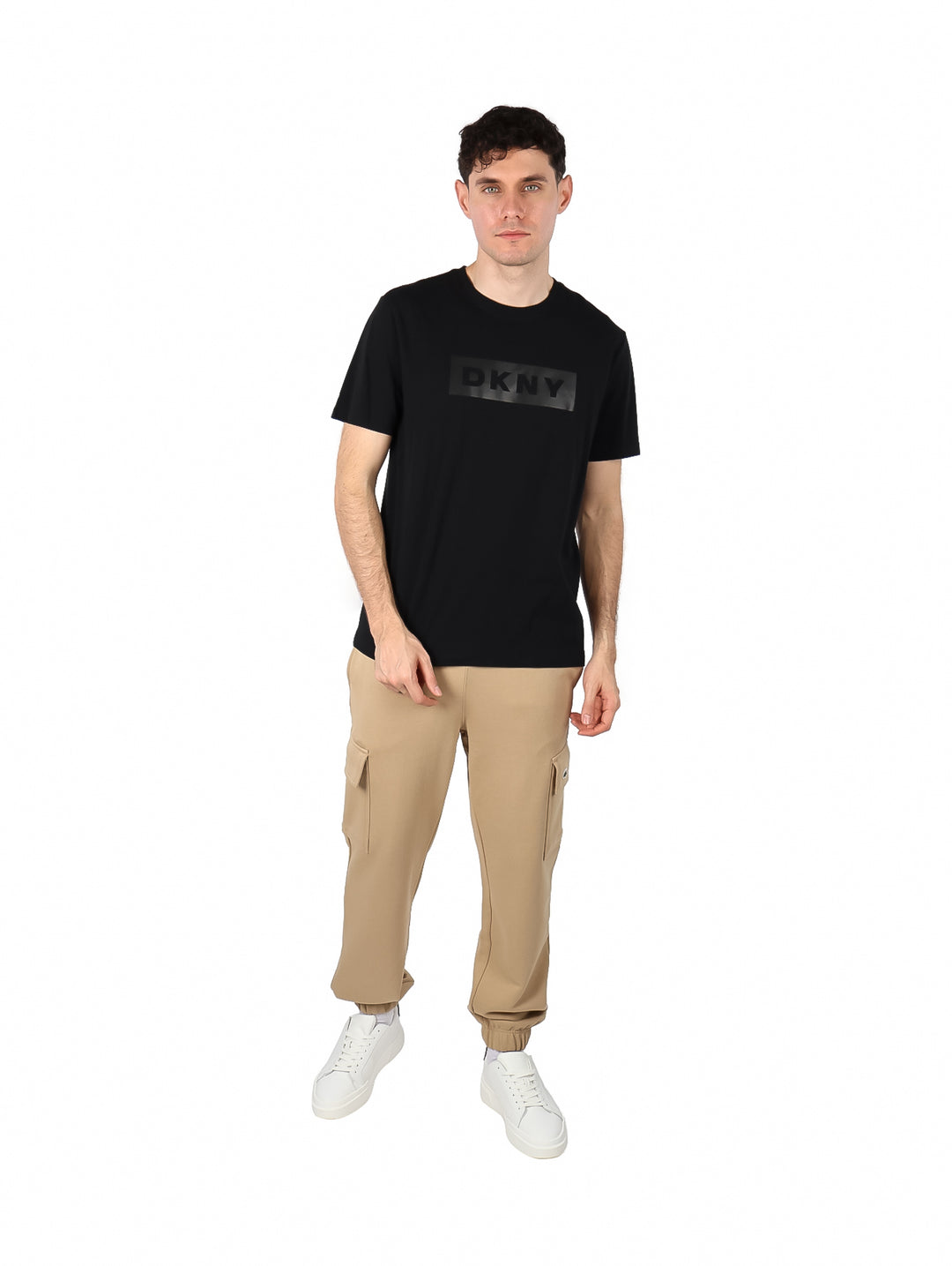 Hombre vistiendo una camiseta negra de manga corta con logotipo DKNY en el pecho.