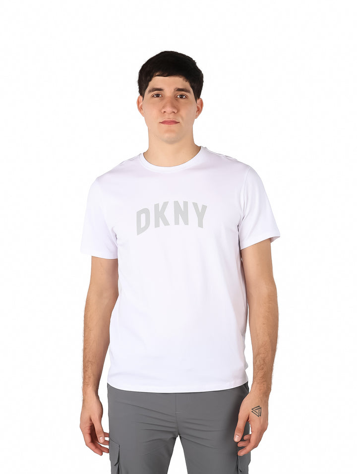Hombre vistiendo una camiseta blanca de manga corta con el logo DKNY en el pecho.