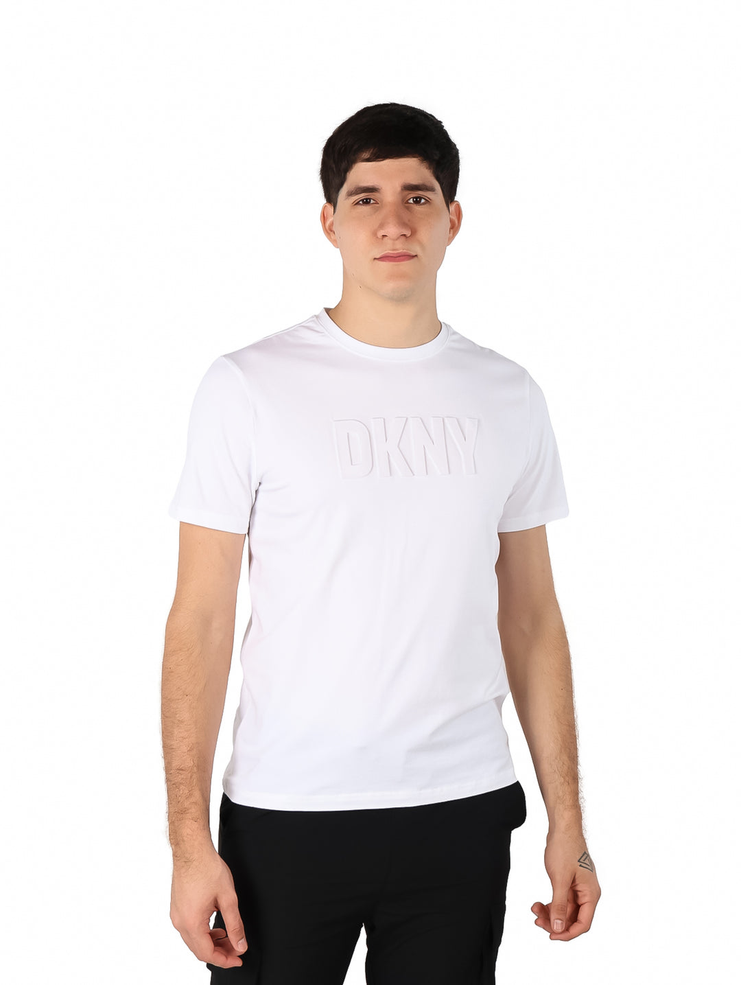 Hombre vistiendo una camiseta blanca de manga corta con logotipo DKNY en relieve en el pecho.