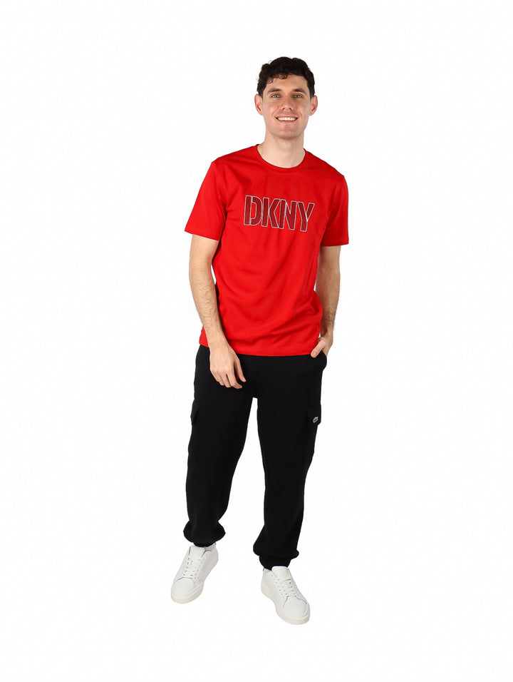 Hombre vistiendo una camiseta roja de manga corta con el logotipo DKNY en el pecho.