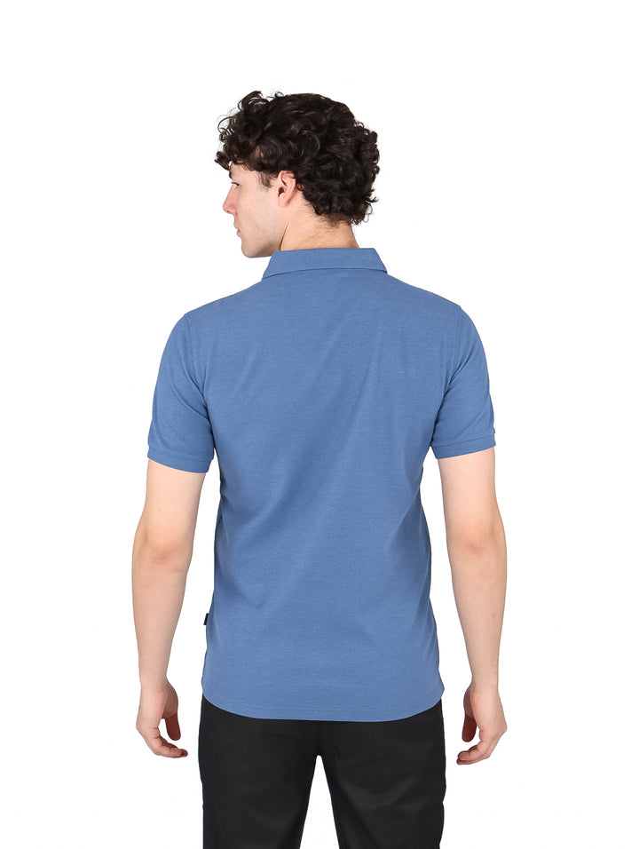 Hombre vistiendo una playera polo de color azul slate con cuello y botones, estilo casual.