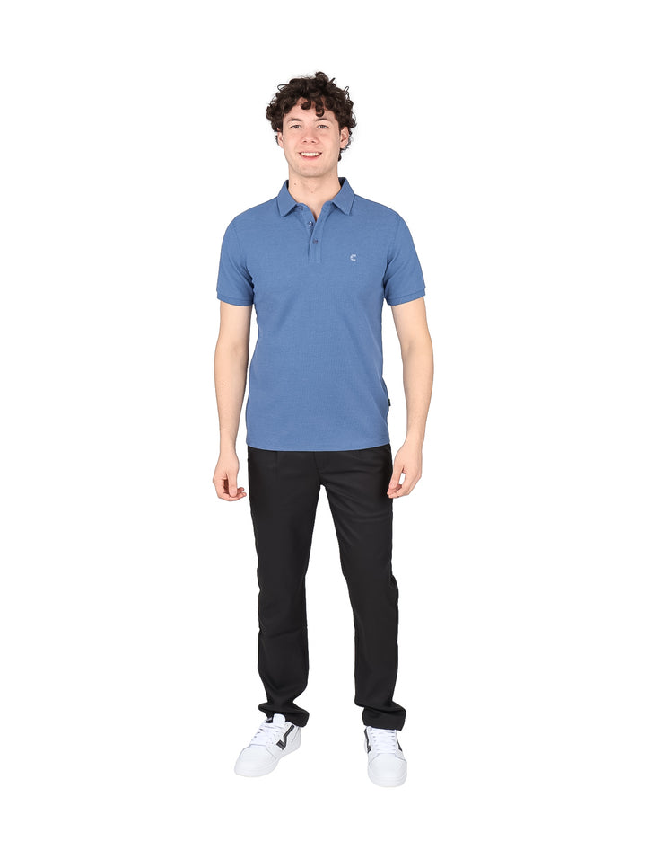 Hombre vistiendo una playera polo de color azul slate con cuello y botones, estilo casual.
