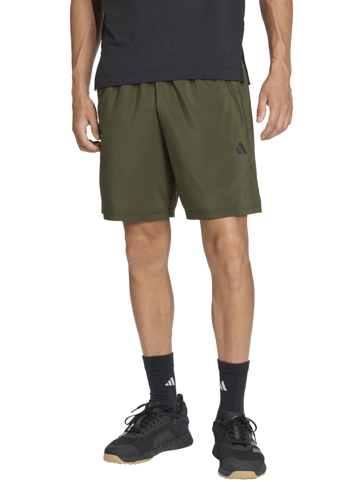 Hombre vistiendo shorts deportivos Adidas color verde oliva Night Cargo.