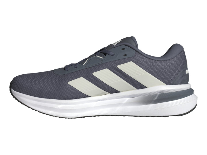 Tenis deportivos Adidas Galaxy 7 color gris con tres franjas blancas y suela blanca.