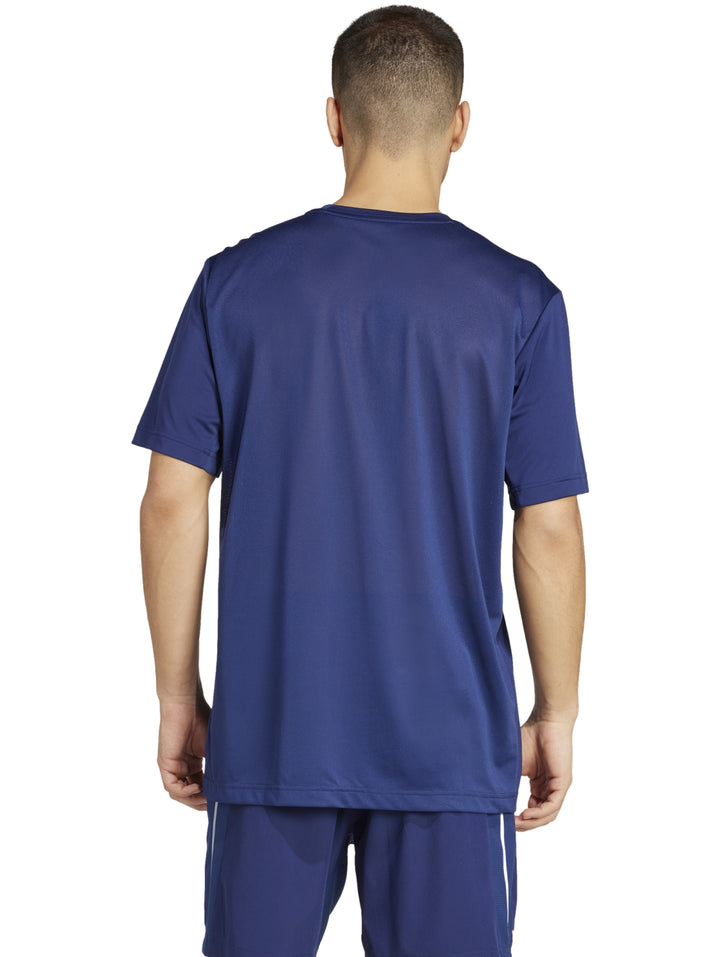 Hombre vistiendo una camiseta deportiva Adidas de color azul oscuro con detalles reflectantes laterales.
