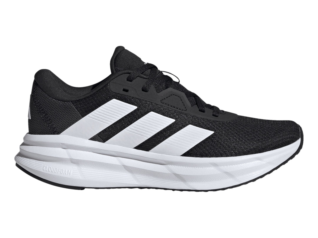 Tenis deportivos Adidas Galaxy 7 color negro con tres franjas y suela blanca.
