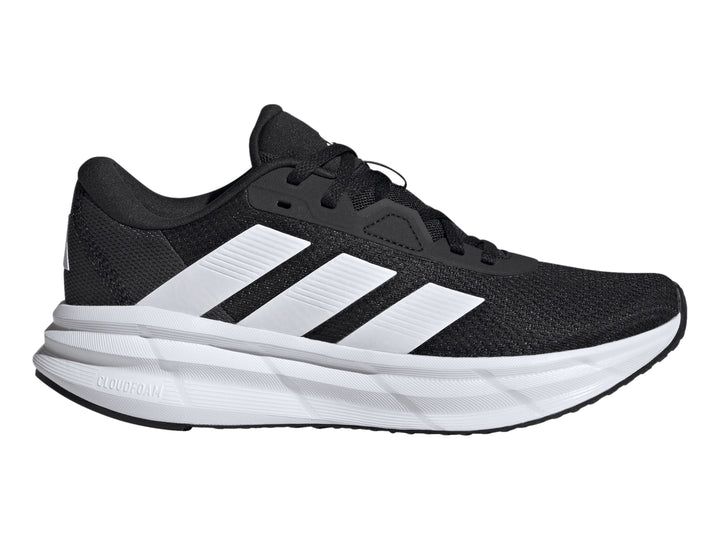 Tenis deportivos Adidas Galaxy 7 color negro con tres franjas y suela blanca.