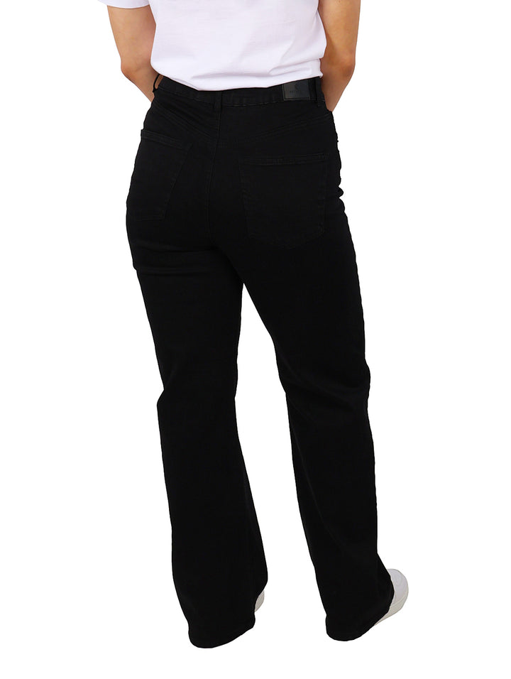 Mujer vistiendo pantalones negros de corte recto y cintura alta.