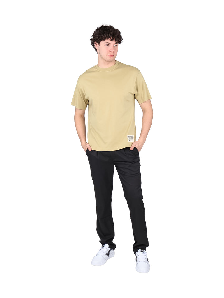 Hombre vistiendo una playera de manga corta color beige con cuello redondo.